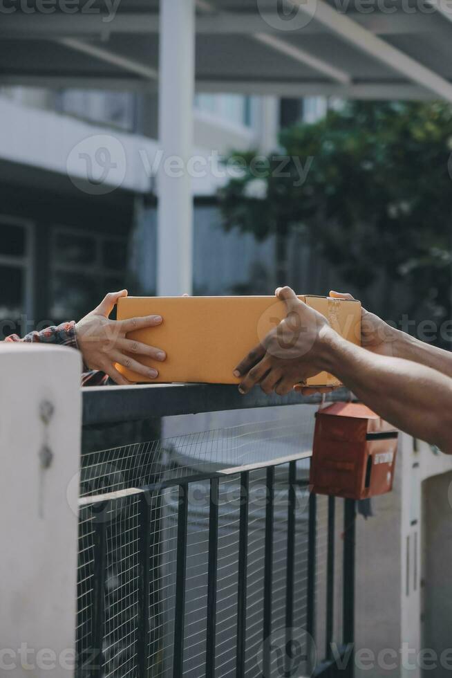 Startup small business entrepreneur of freelance Asian woman using a laptop with box Cheerful success Asian woman her hand lifts up online marketing packaging box and delivery SME idea concept photo