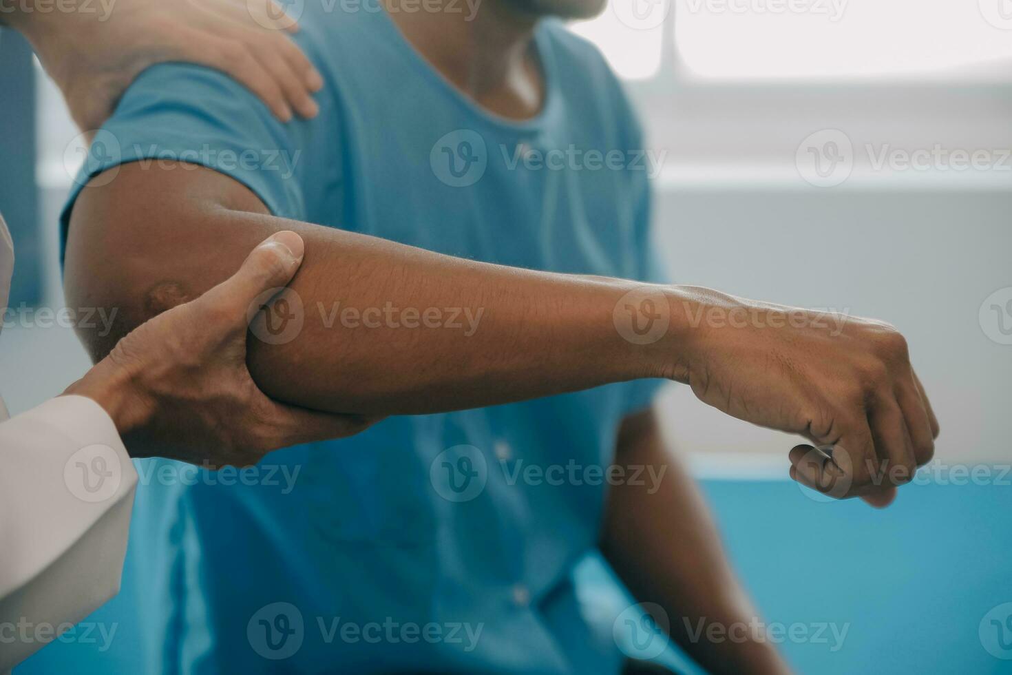 médico o fisioterapeuta trabajando examinando tratando lesionado brazo de atleta masculino paciente, extensión y ejercicio, haciendo el rehabilitación terapia dolor en clínica. foto