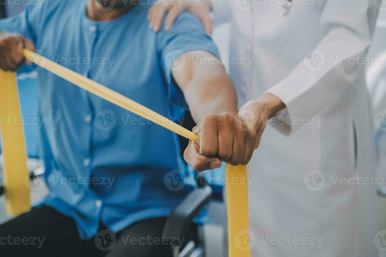 Physical therapist guiding patient with resistance band photo