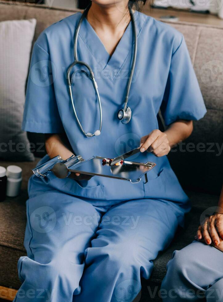 Doctor and patient sitting and talking at medical examination at hospital office, close-up. Therapist filling up medication history records. Medicine and healthcare concept. photo