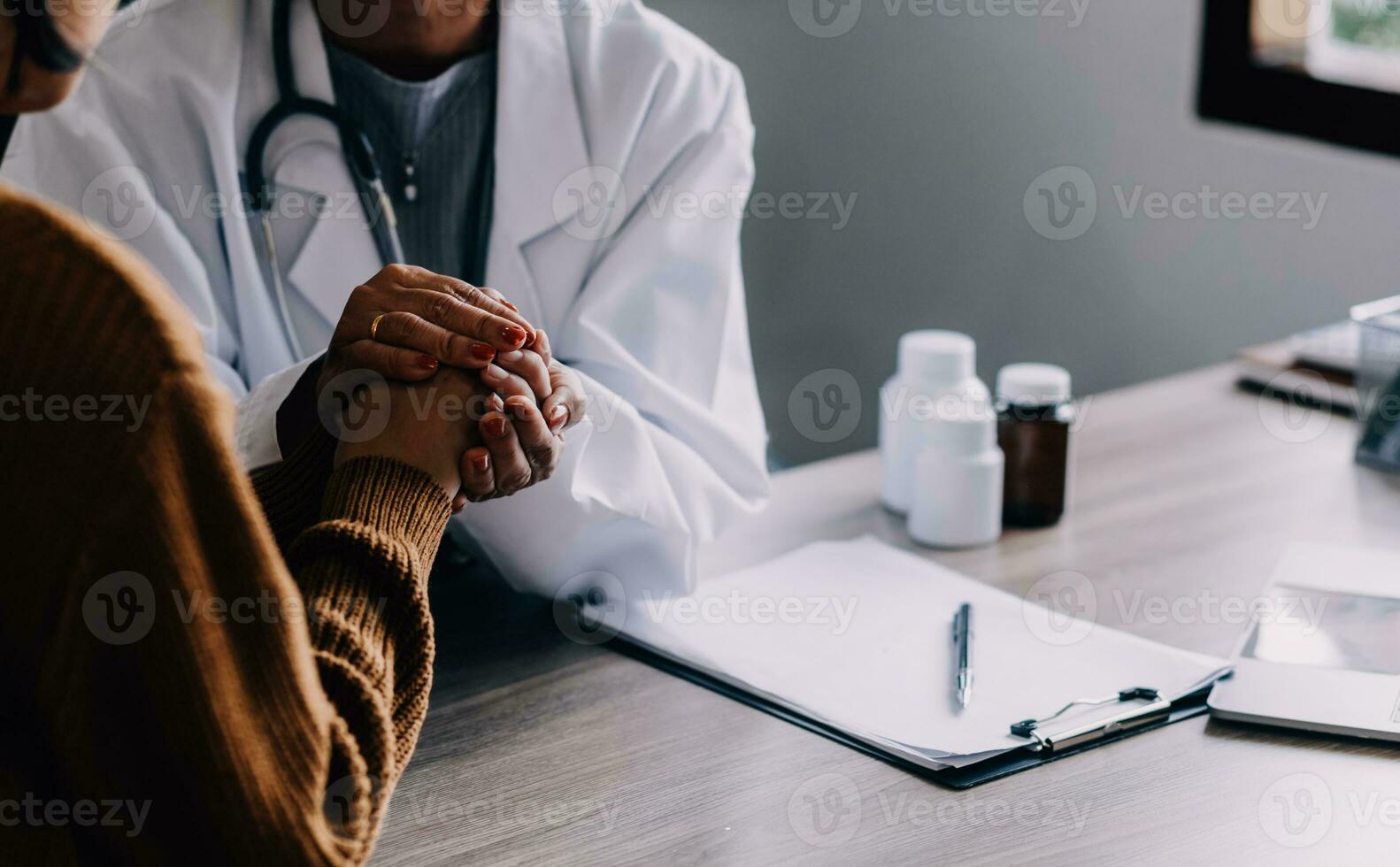 Young psychologist holding hand of her patient in need while consulting her after discussion of problem photo