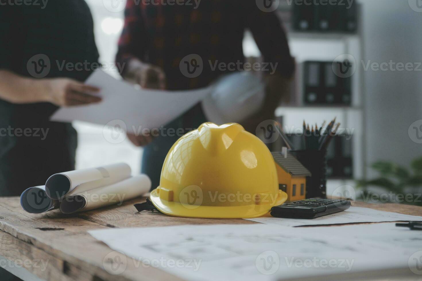 Close up of civil male engineer asian working on blueprint architectural project at construction site at desk in office. photo