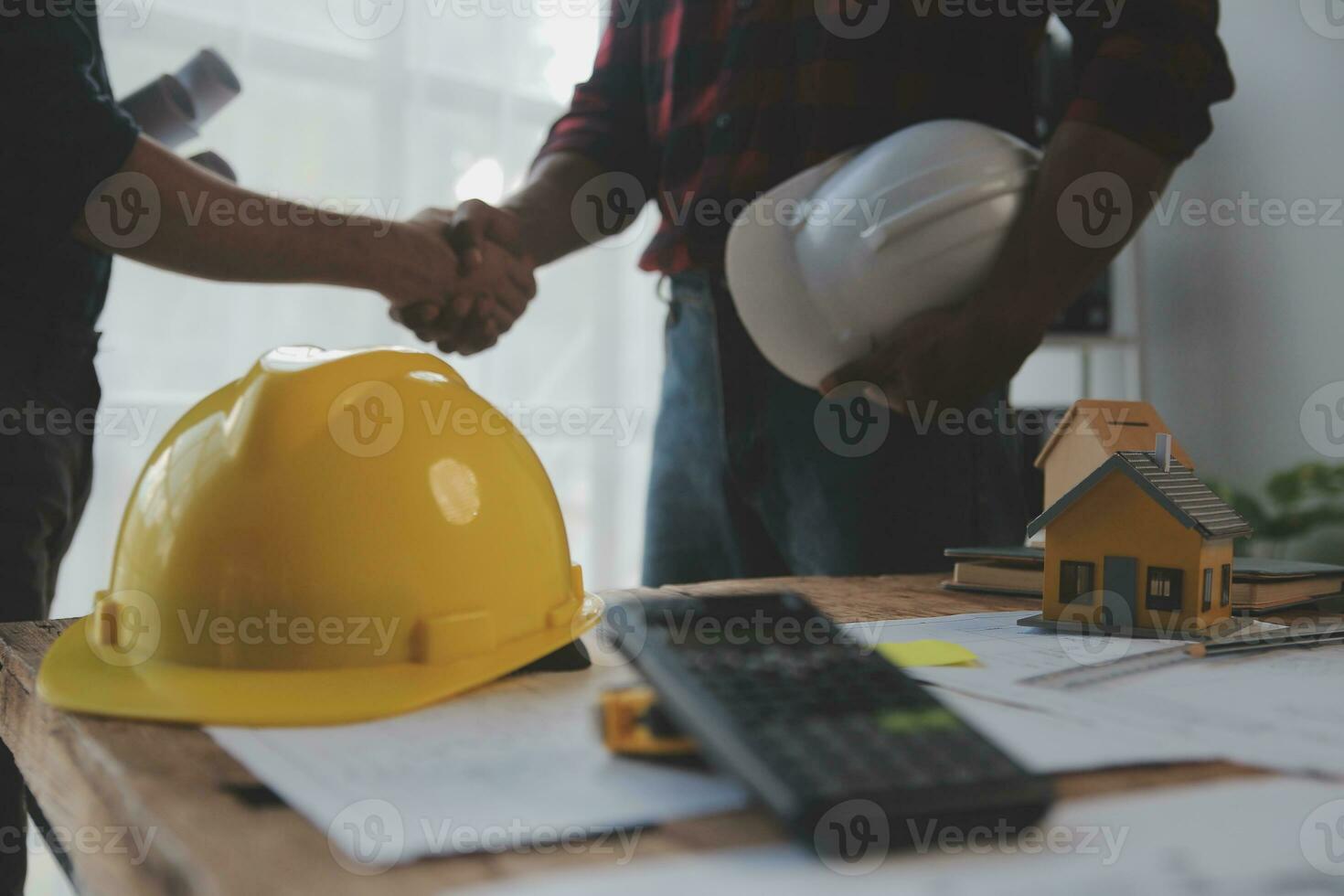 Close up of civil male engineer asian working on blueprint architectural project at construction site at desk in office. photo