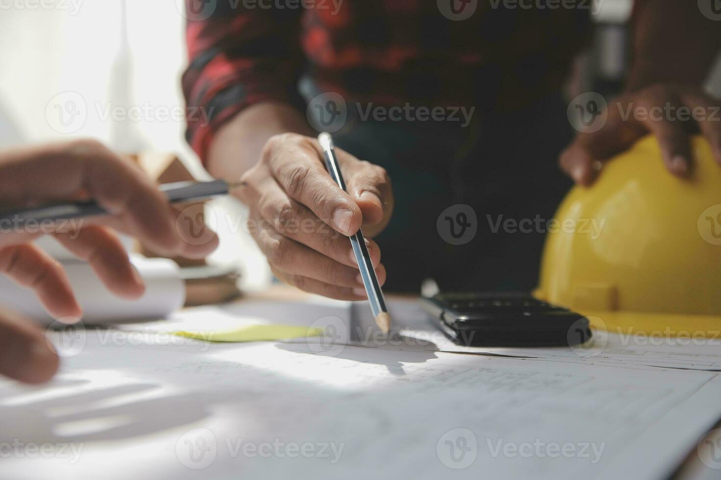 Close up of civil male engineer asian working on blueprint architectural project at construction site at desk in office. photo