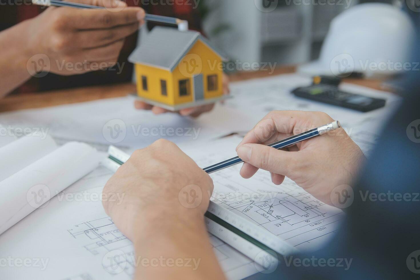 Close up of civil male engineer asian working on blueprint architectural project at construction site at desk in office. photo