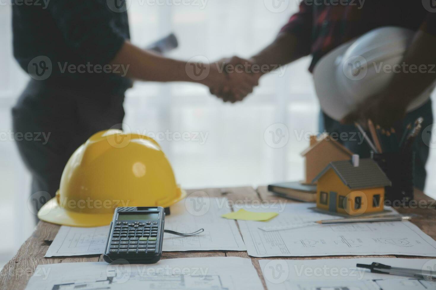 Close up of civil male engineer asian working on blueprint architectural project at construction site at desk in office. photo