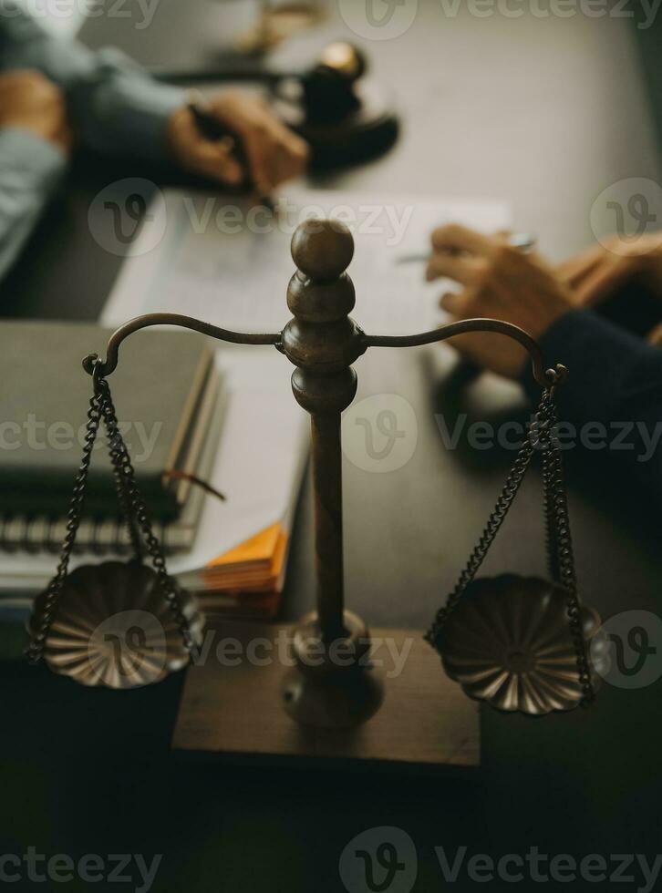 concepto de justicia y derecho. El asesor legal presenta al cliente un contrato firmado con mazo y derecho legal o una reunión de equipo legal en el bufete de abogados en segundo plano. foto