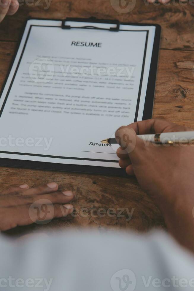 Close up view of job interview in office, focus on resume writing tips, employer reviewing good cv of prepared skilled applicant, recruiter considering application, hr manager making hiring decision photo