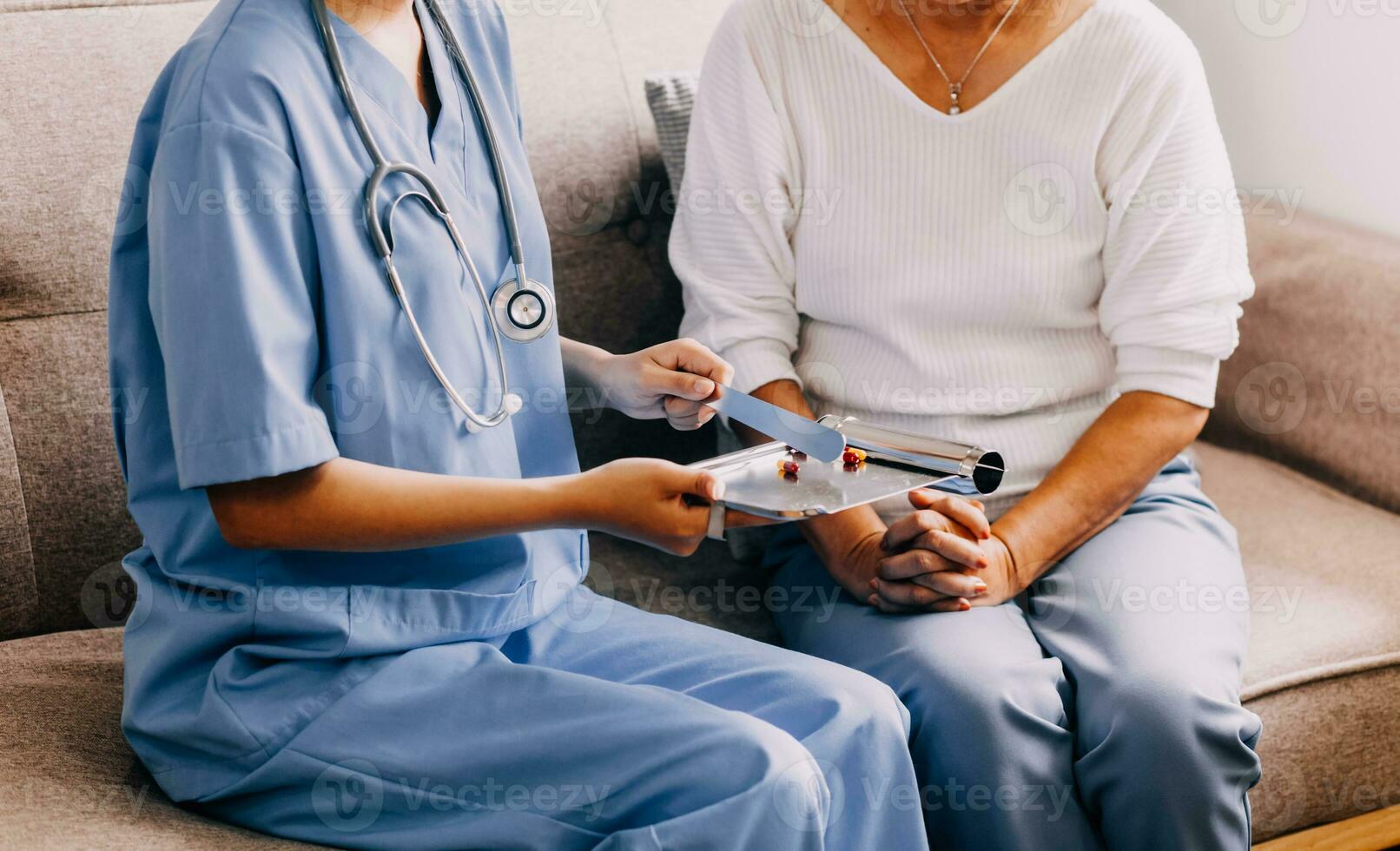 Doctor and patient sitting and talking at medical examination at hospital office, close-up. Therapist filling up medication history records. Medicine and healthcare concept. photo
