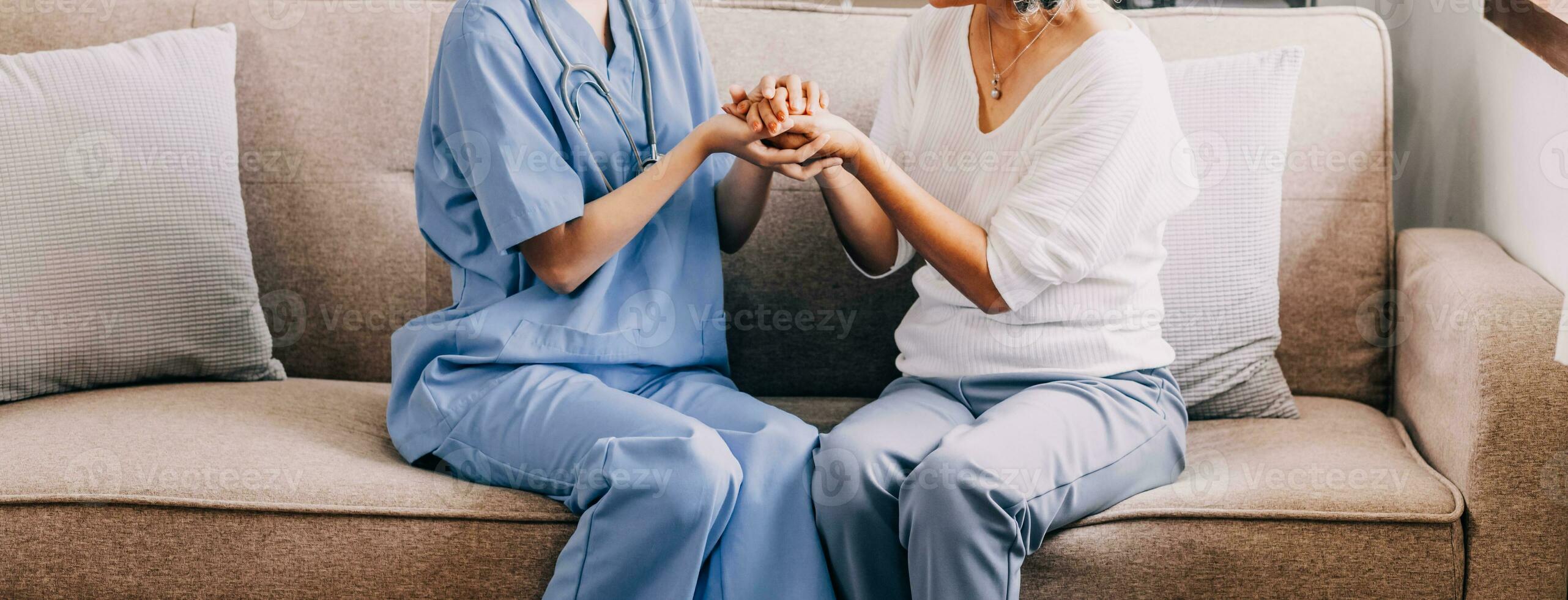 Happy senior woman visiting doctor, getting optimistic news after medical checkup, therapy. Therapist holding hand of old patient, giving hope, support, congratulating on goor treatment result photo