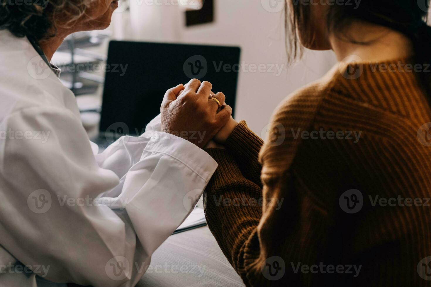 Young psychologist holding hand of her patient in need while consulting her after discussion of problem photo