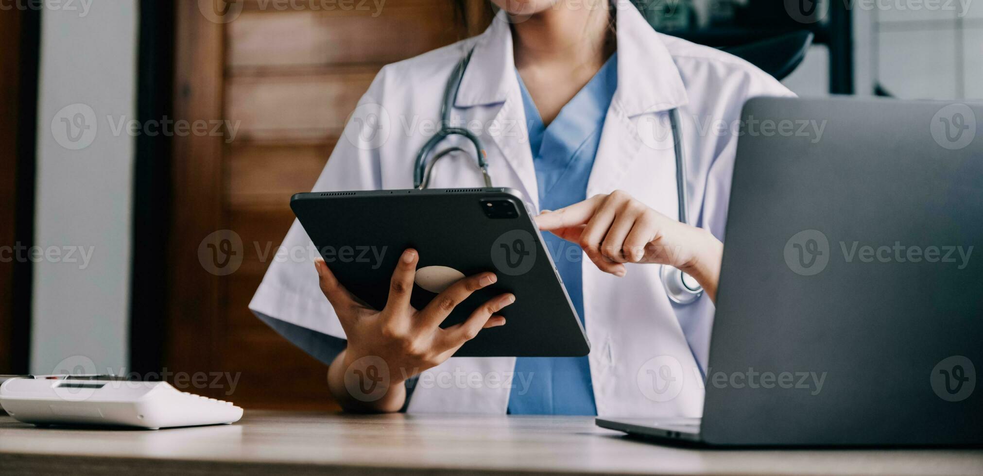 Medical doctor or physician consulting patient's health online using internet mobile digital tablet in clinic or hospital office for professional emergency healthcare assistance service concept photo