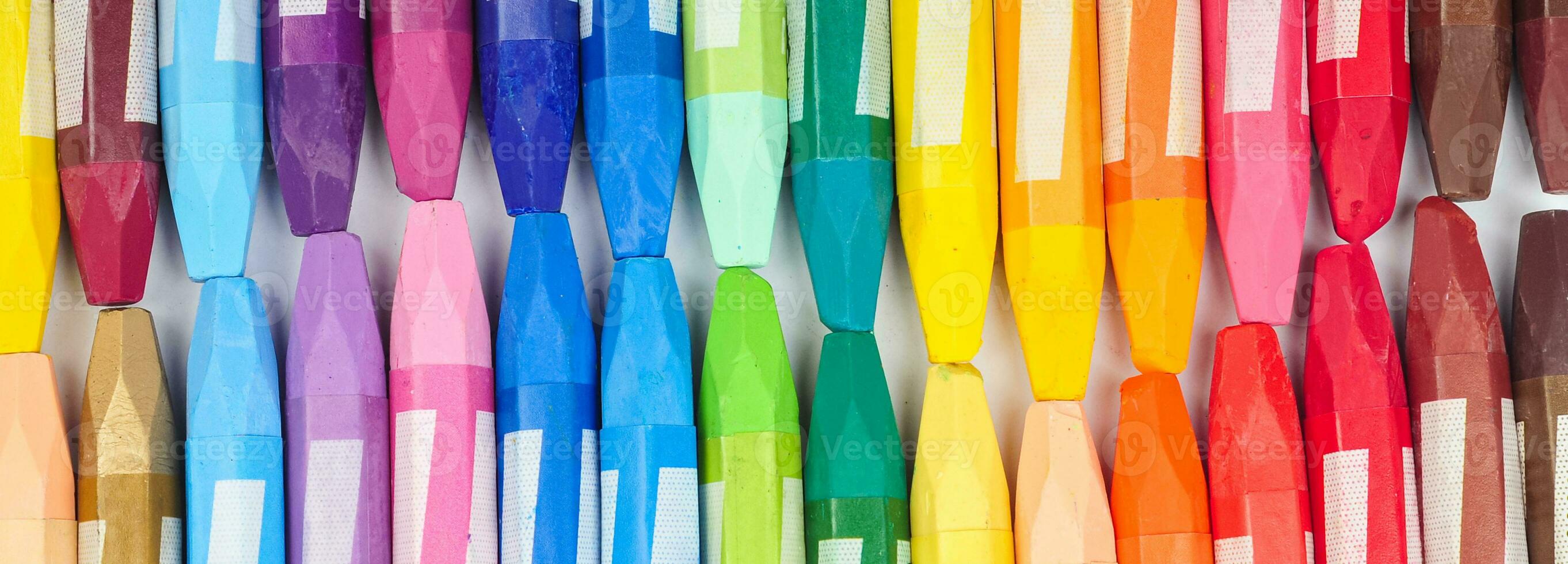 a collection of neatly arranged crayon sticks visible from above in a row of colorful colors photo