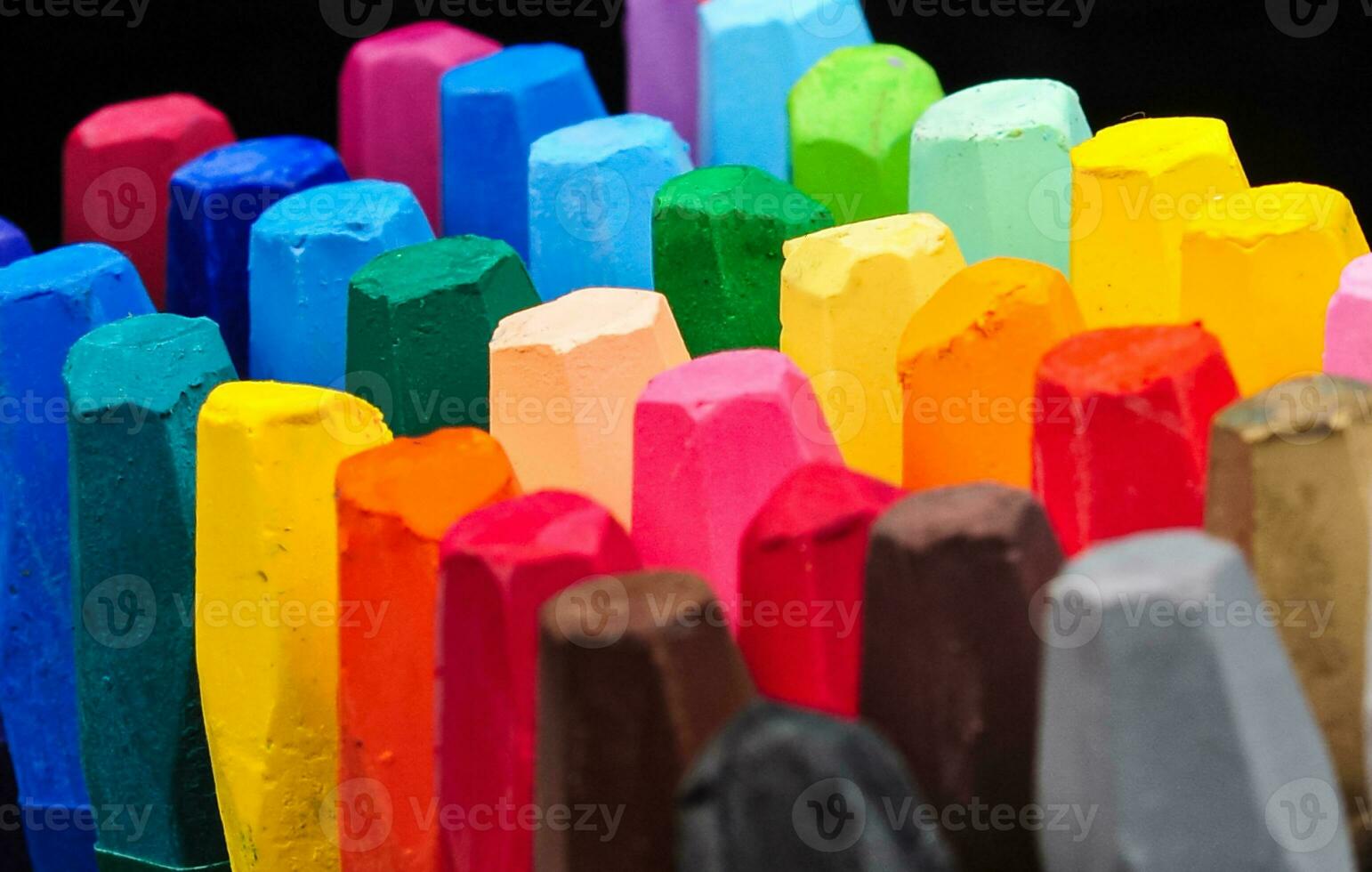 a collection of neatly arranged crayon sticks visible from above in a row of colorful colors photo