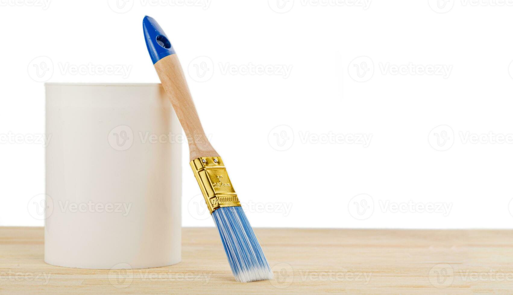 white paint with a brush on a wooden background with texture photo