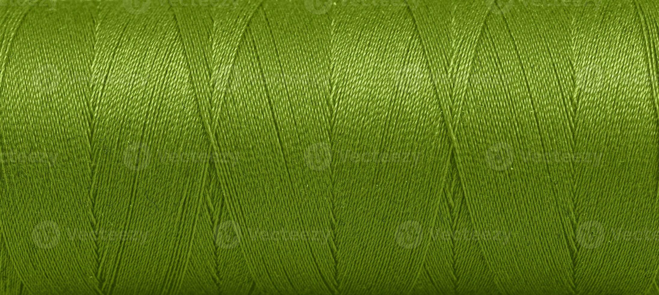 Texture of threads in a spool of green color on a white background photo