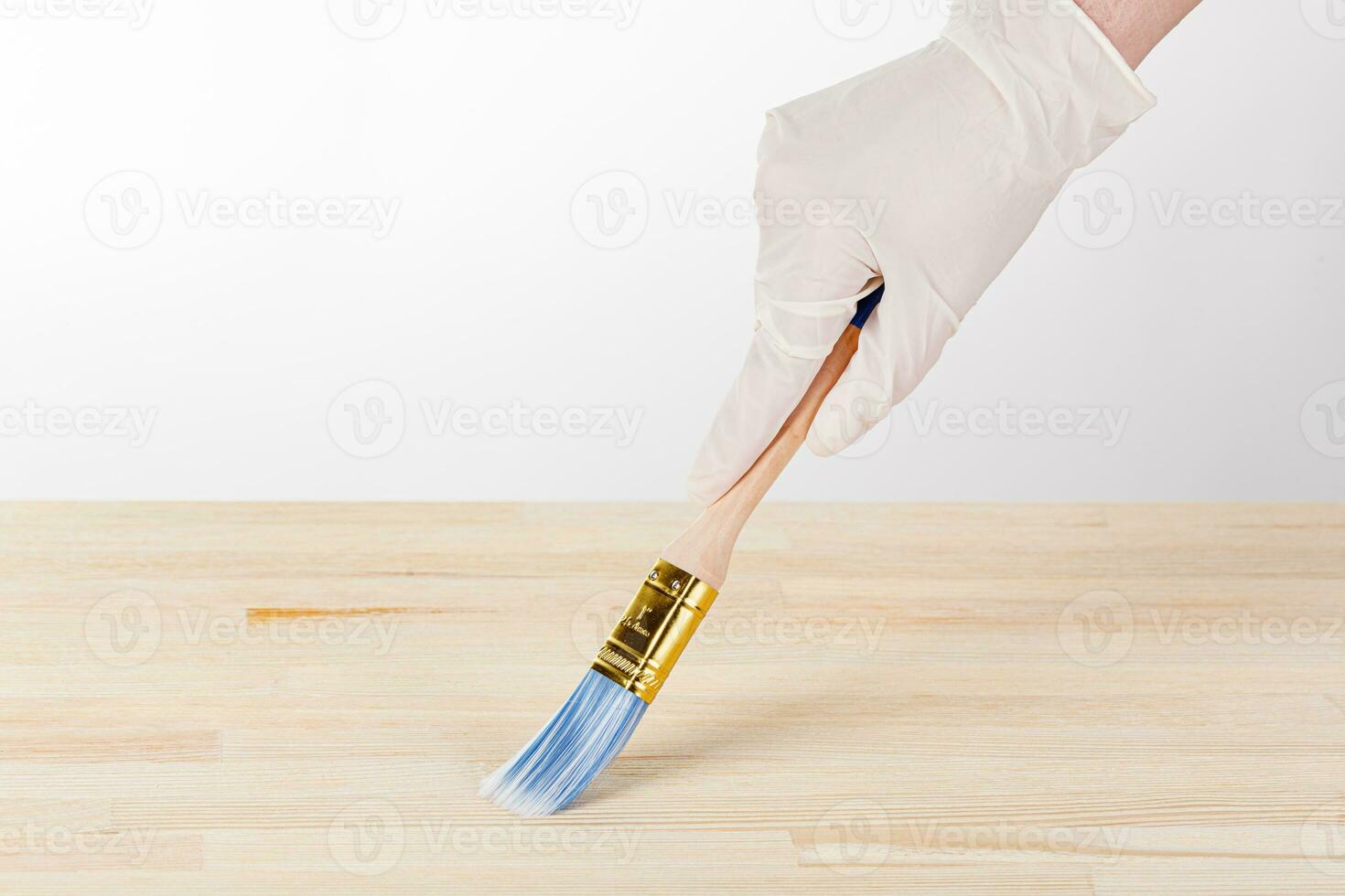painting wooden background, hand with brush and can of paint photo
