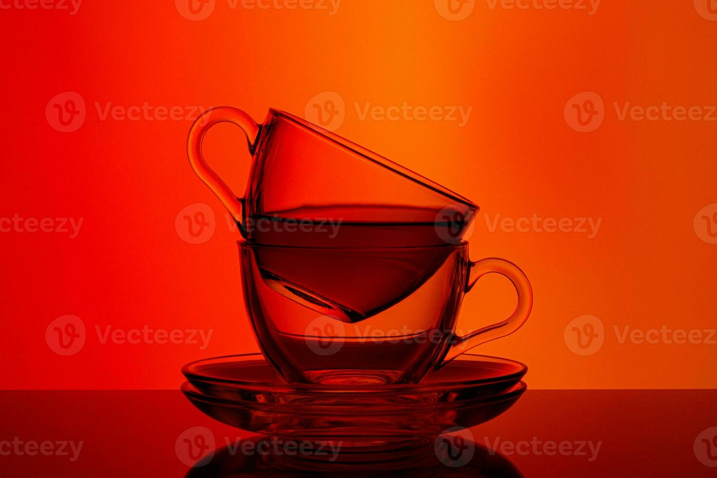 beautiful two cups with tea on orange and red background photo