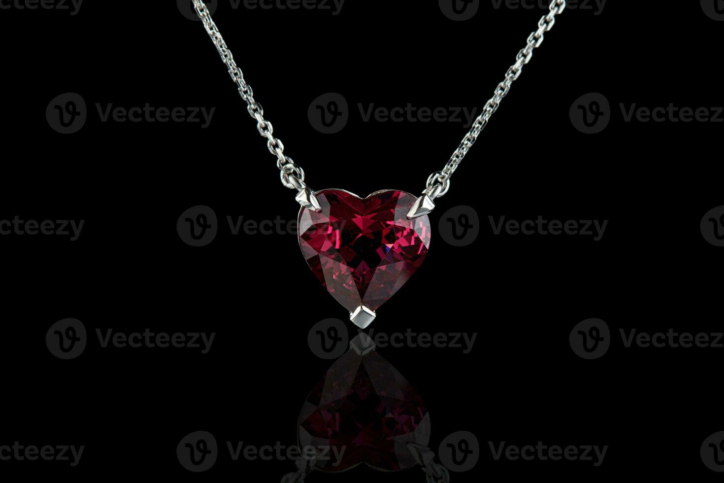 beautiful pendant with garnet with a gold chain on a black background photo