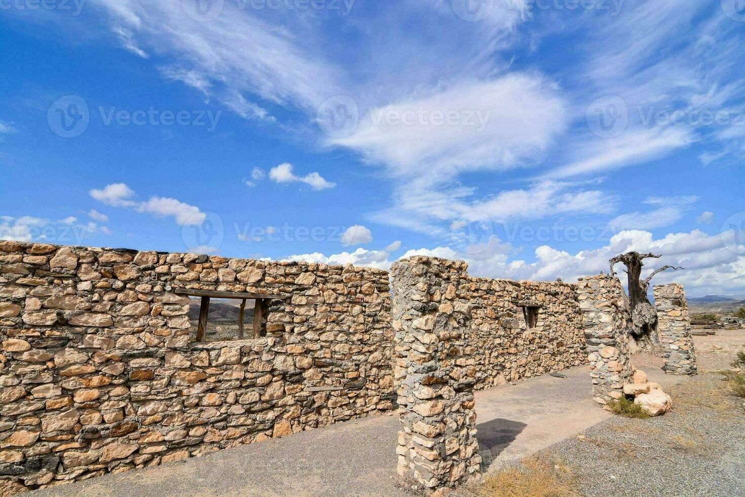 an old stone building with a blue sky and clouds photo