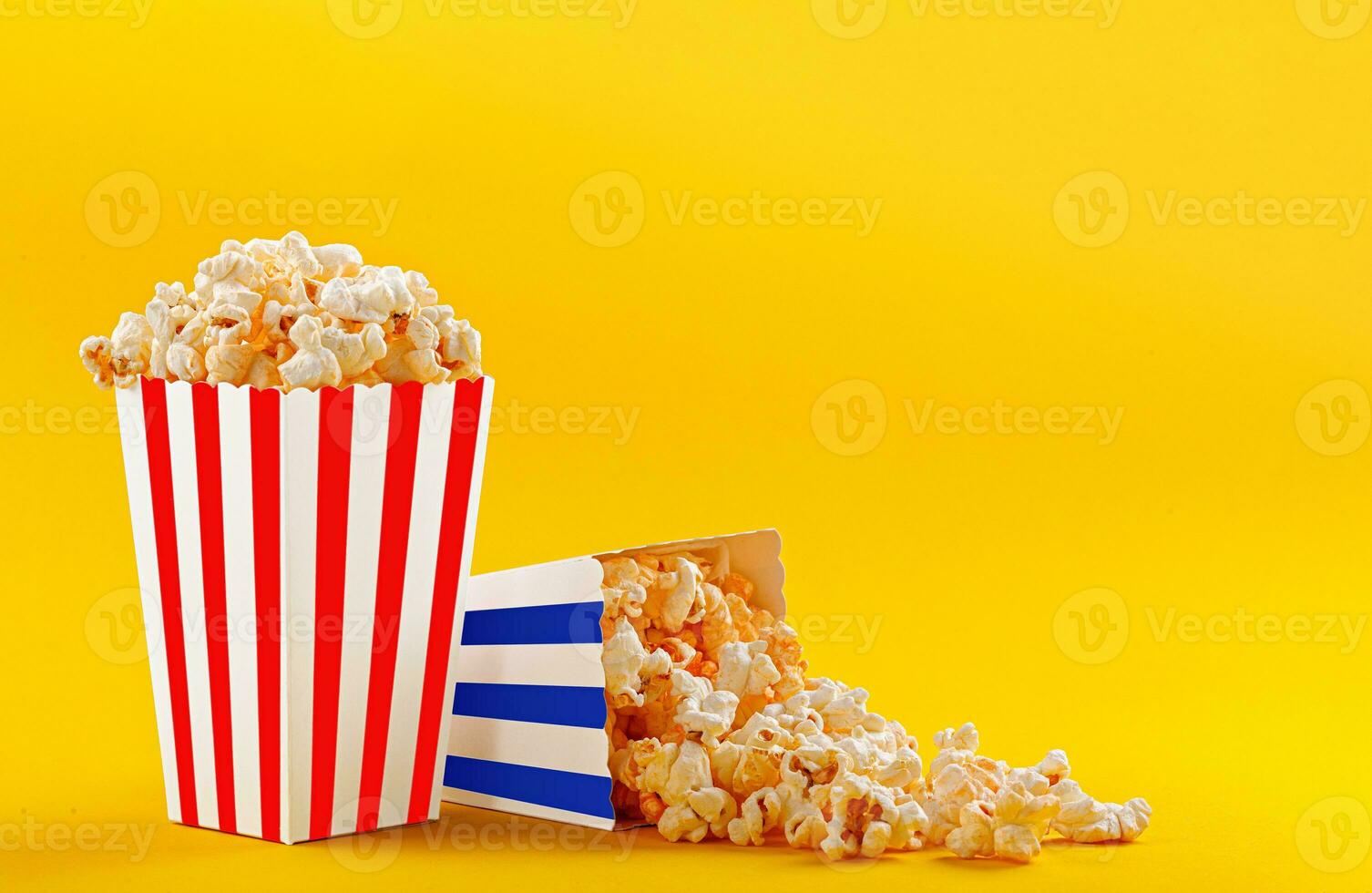 Glass with popcorn on a yellow background photo