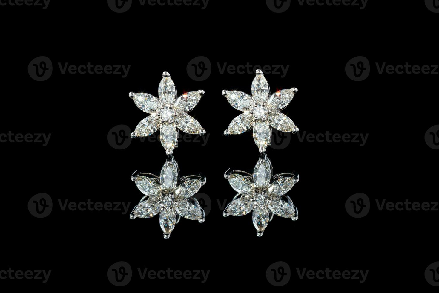 beautiful gold earrings with diamonds gemstones on a black background photo