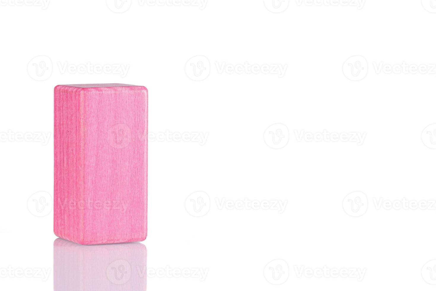 Wooden cube of pink color on a white background photo