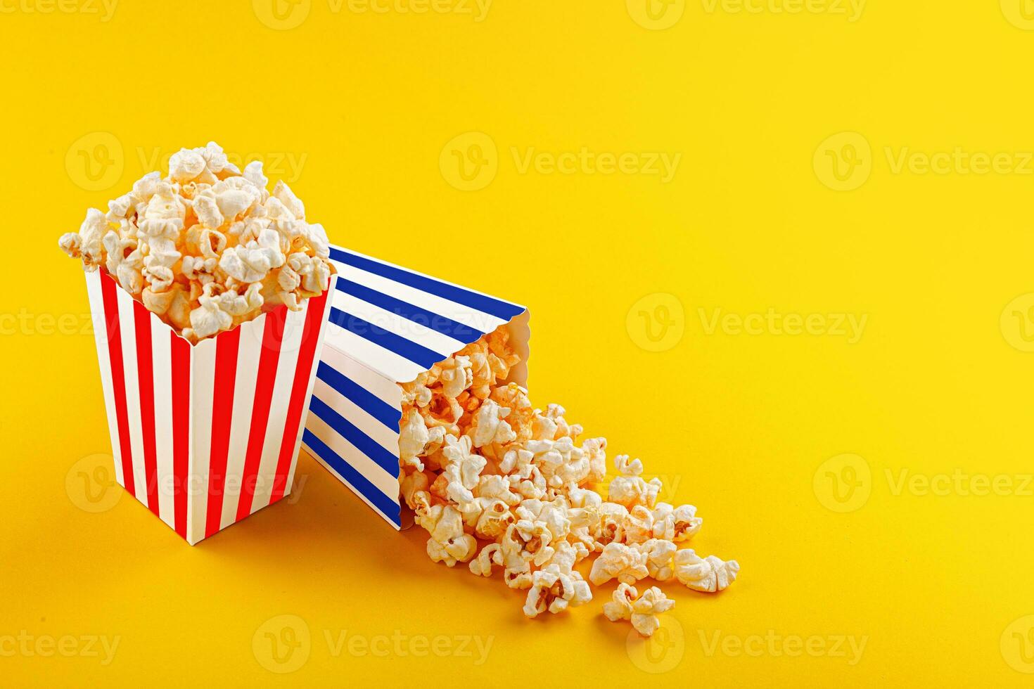 Glass with popcorn on a yellow background photo