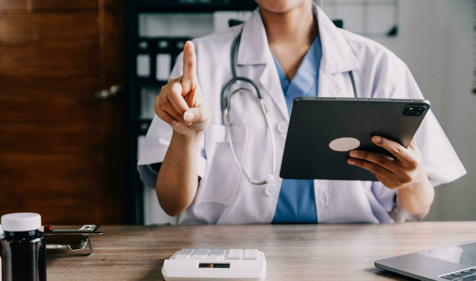 Medical doctor or physician consulting patient's health online using internet mobile digital tablet in clinic or hospital office for professional emergency healthcare assistance service concept photo