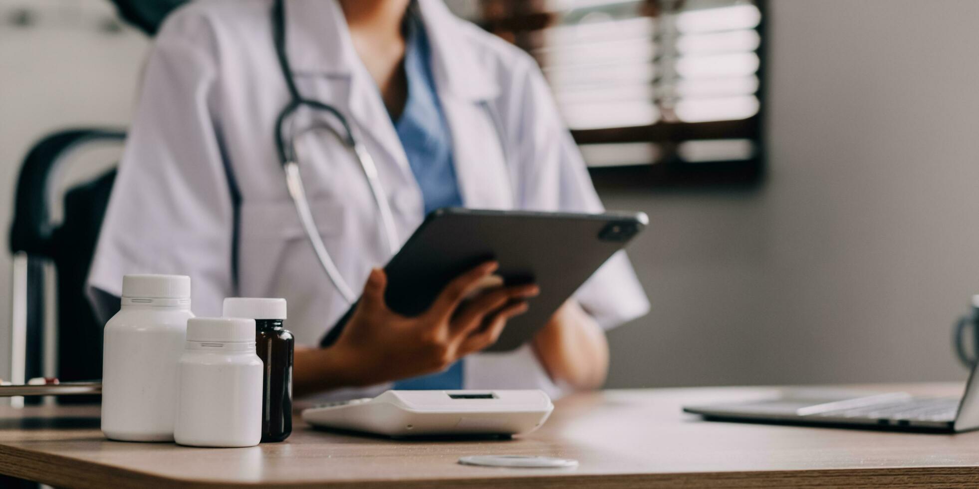 Concerned young female Caucasian doctor in white medical uniform sit at desk in hospital work on laptop, focused woman nurse or GP busy fill anamnesis on computer gadget, medicine, technology concept photo