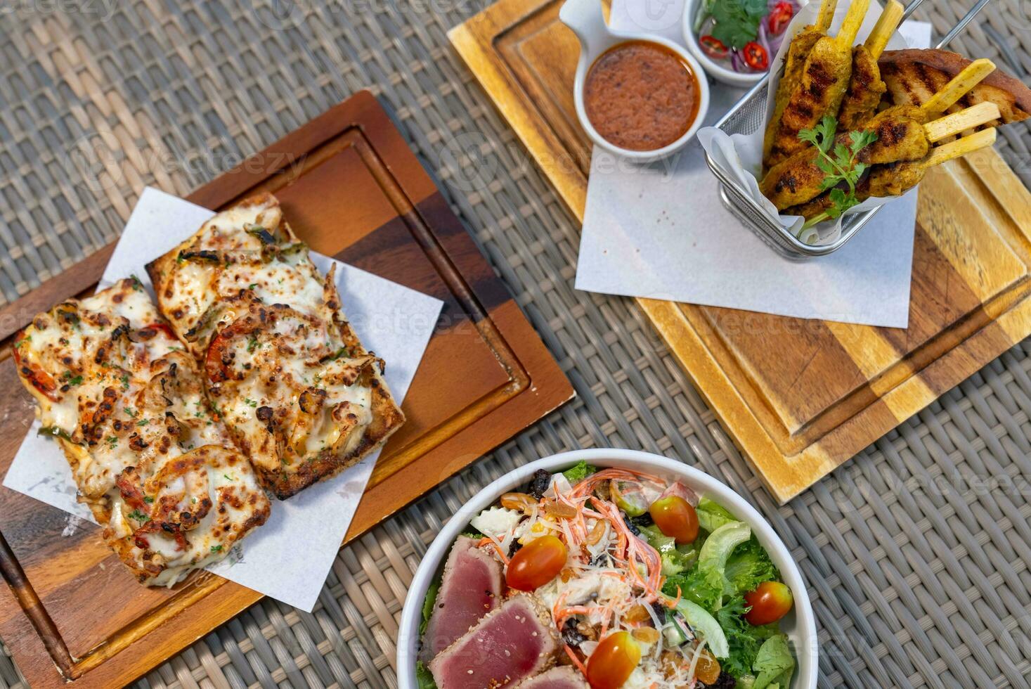 Pizza, french fries, beef steak on a wooden plate photo
