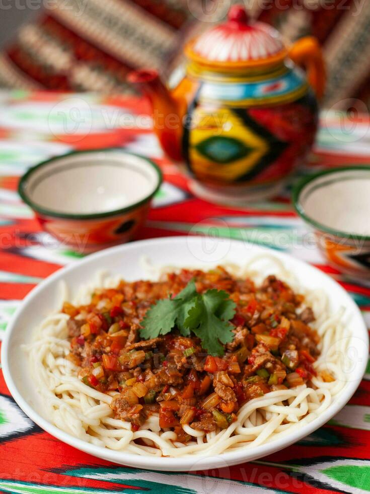 The oriental dish guiru lagman is homemade noodles fried with meat, vegetables and herbs. Eastern cuisine photo