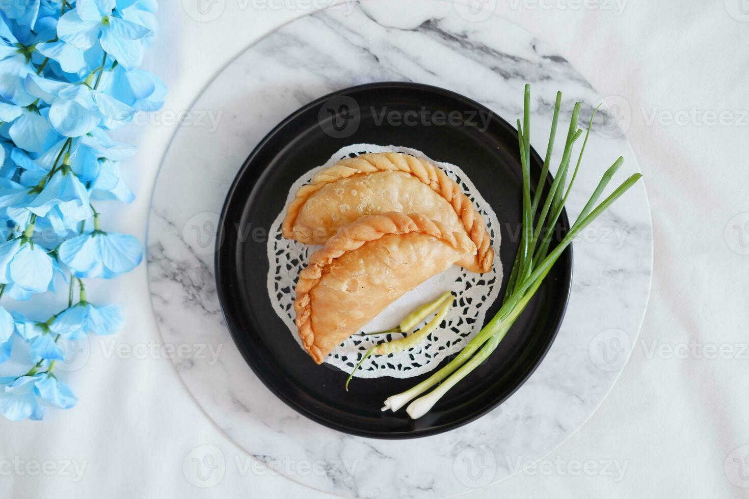 Curry puff or Pastel Goreng is Pastry Popular in Indonesia.fried pastry with filling of sauted vegetable , chicken and boiled egg. accompanied with  sauce or raw chilli pepper photo