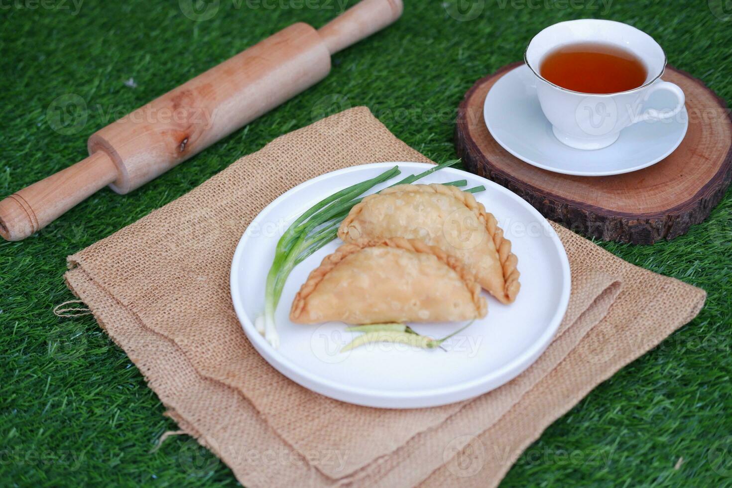 Curry puff or Pastel Goreng is Pastry Popular in Indonesia. fried pastry with filling of sauted vegetable, chicken and boiled egg. accompanied with  sauce or raw chilli pepper photo