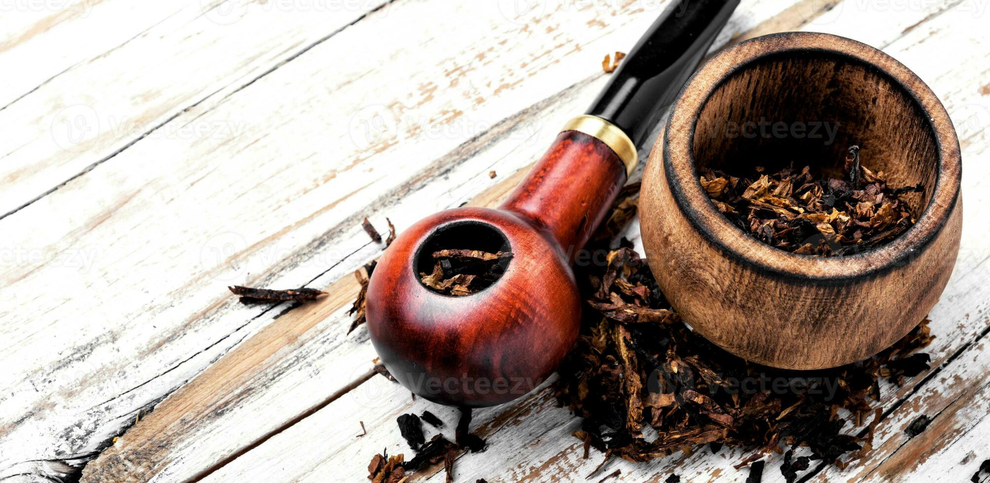 Smoking pipe on a wooden table photo
