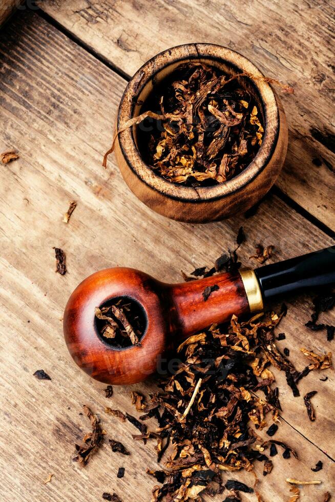 Smoking pipe on a wooden table photo