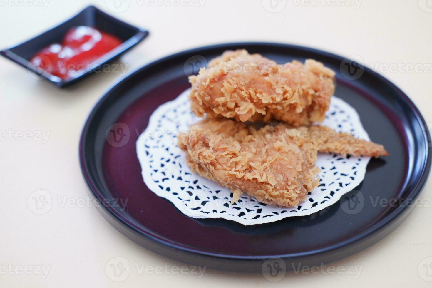 Crispy fried chicken on a plate with sauce, stock photo