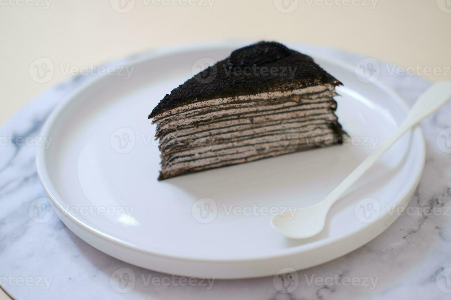 Piece of homemade chocolate crepes cake on a white plate photo