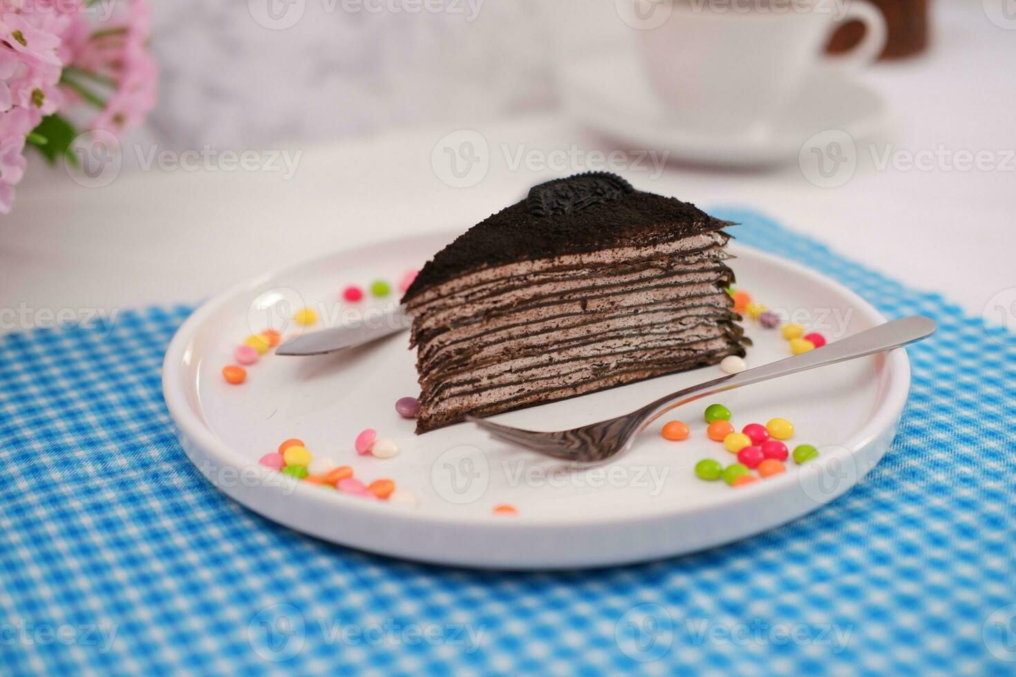 Piece of homemade chocolate crepes cake on a white plate photo