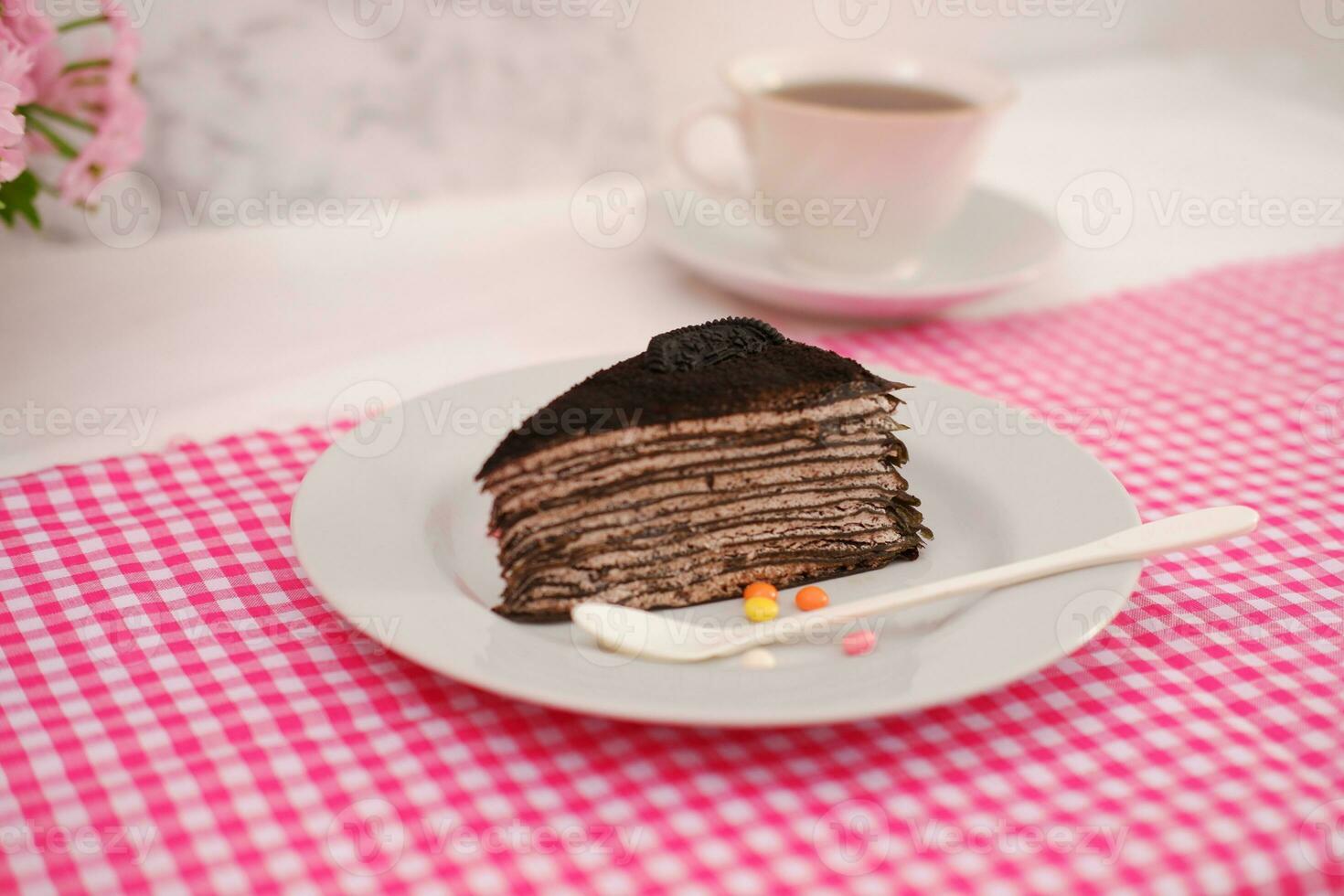 Piece of homemade chocolate crepes cake on a white plate photo