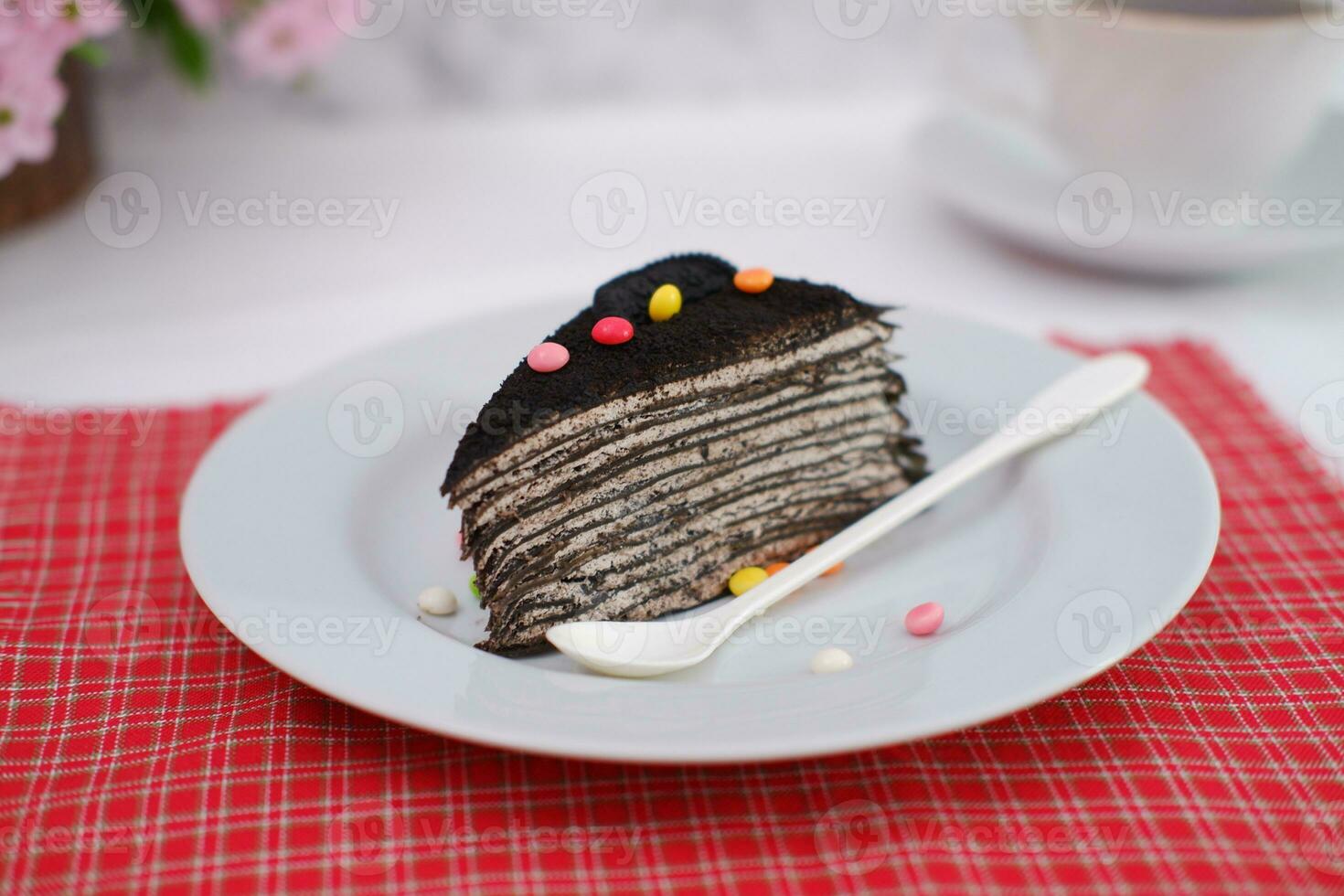 Piece of homemade chocolate crepes cake on a white plate photo