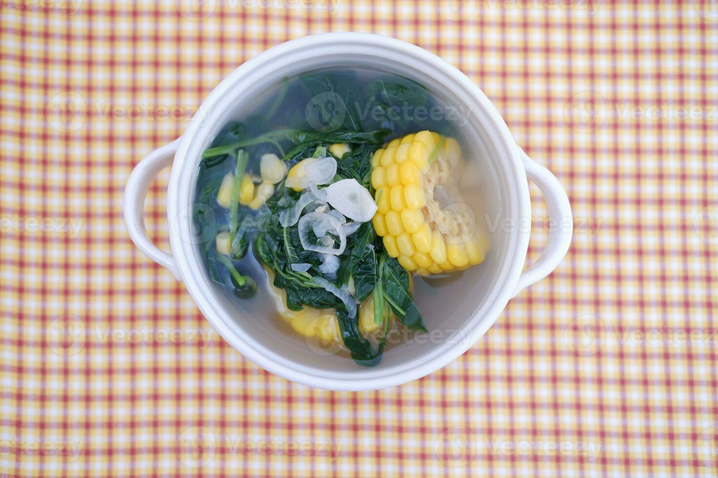 Sayur Bening Daun kelor jagung or Moringa Oleifera clear soup with sweet corn served in bowl photo
