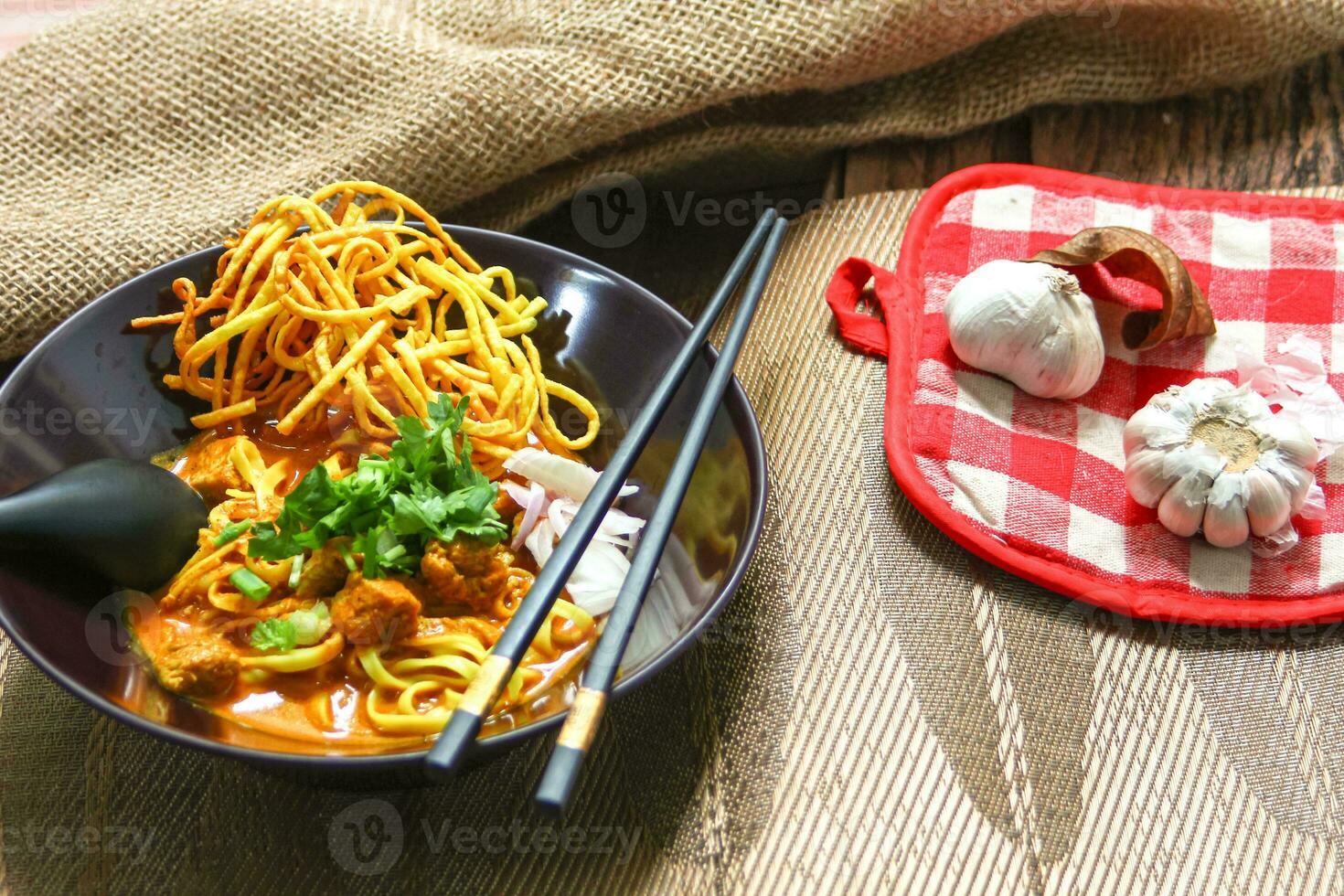 Noodles with pork and vegetables in a bowl on the table, Khao Soi Kai, Northern Style Curried Noodle Soup with choice of pickled chicken photo