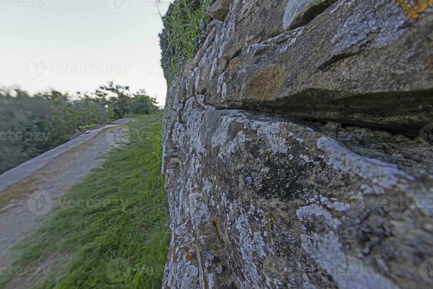 Close-up of a natural stone wall with sharpness in the center of the image and blurring at the edge photo