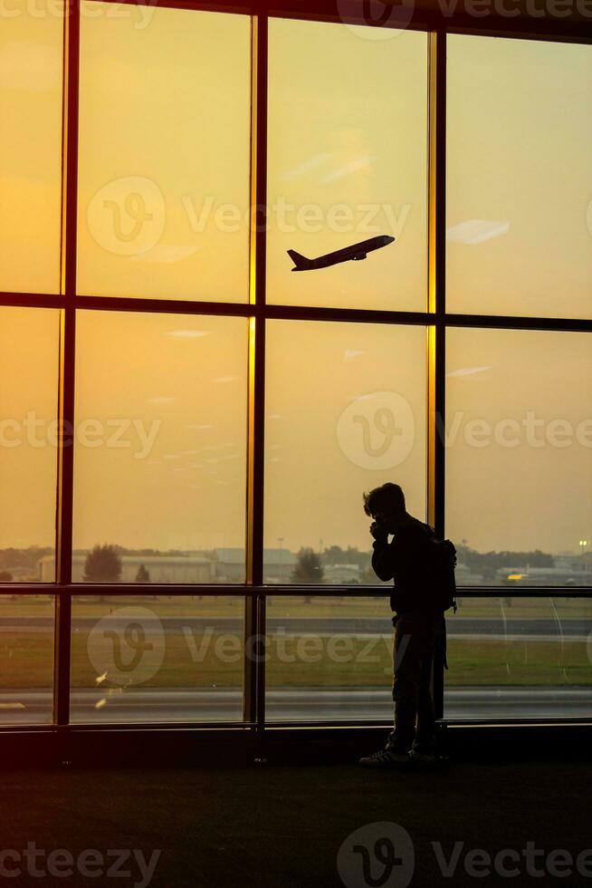 silueta de un hombre a el aeropuerto con un avión en el antecedentes foto