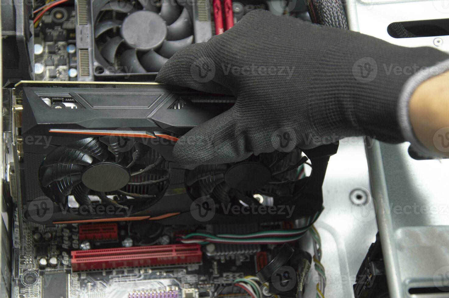 Top view of graphics card being assembled by technician on motherboard, computer repair photo