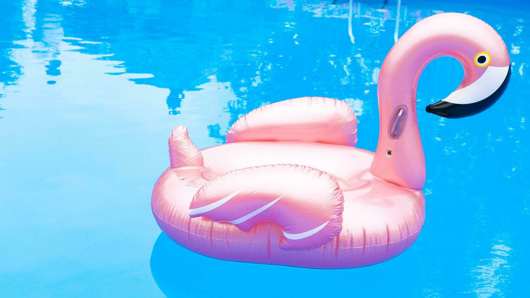 inflable rosado flamenco en el piscina foto