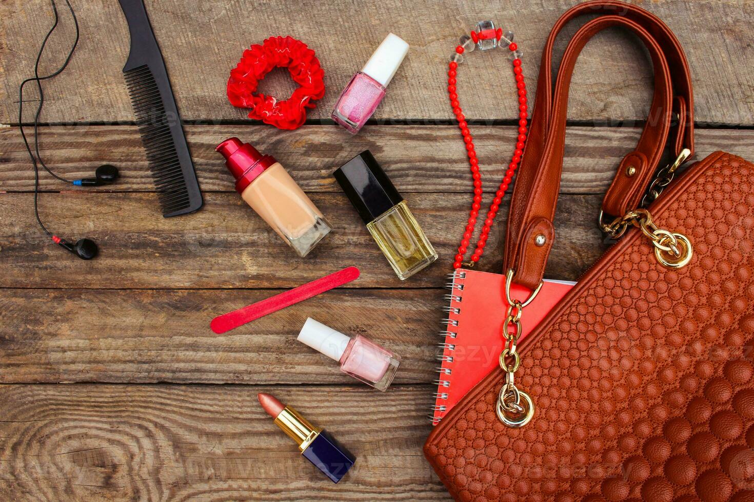 Things from open lady handbag. women's purse on wood background. Toned image. photo