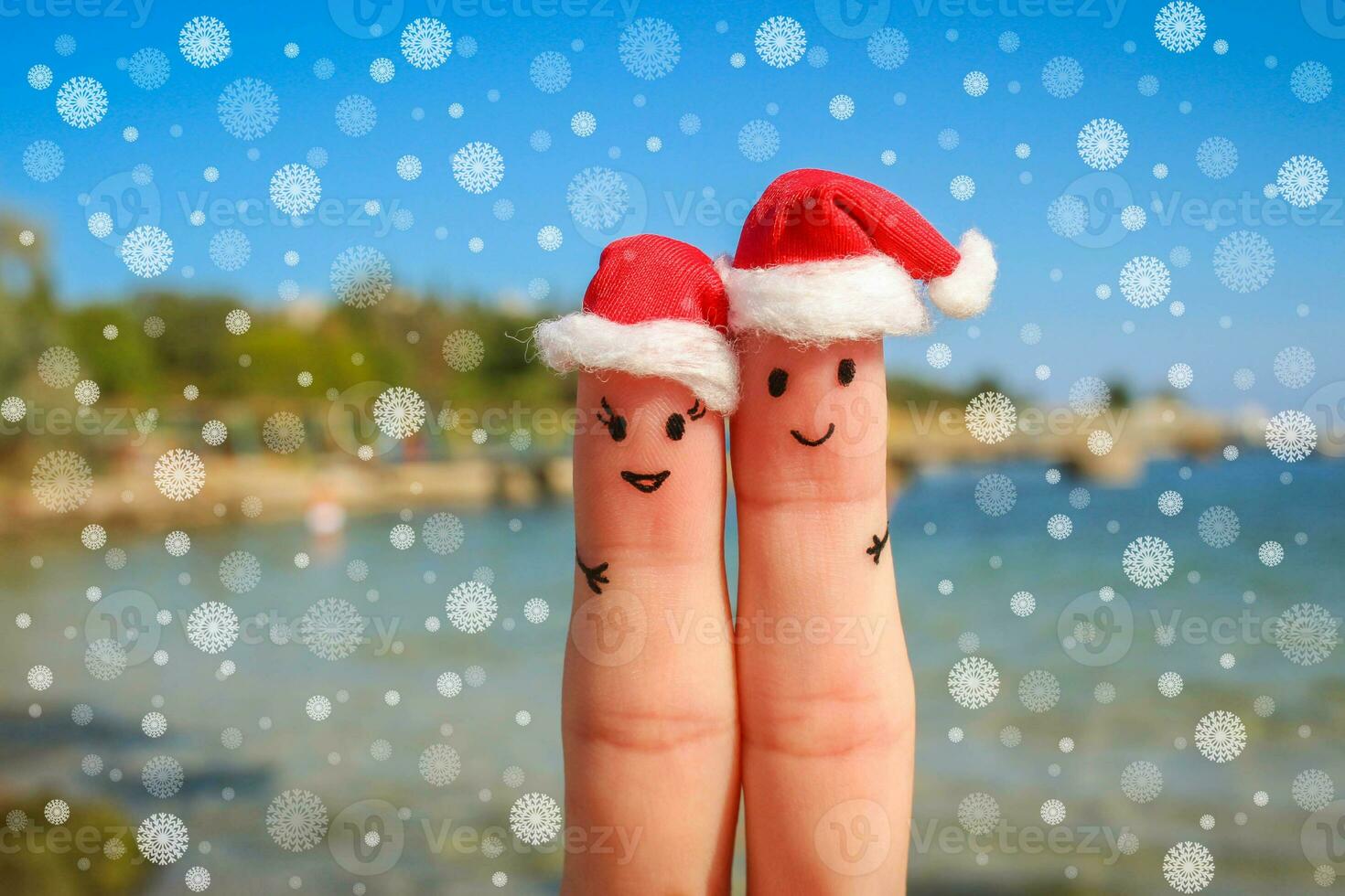 dedo Arte de contento Pareja en Navidad sombreros descansando en el mar foto