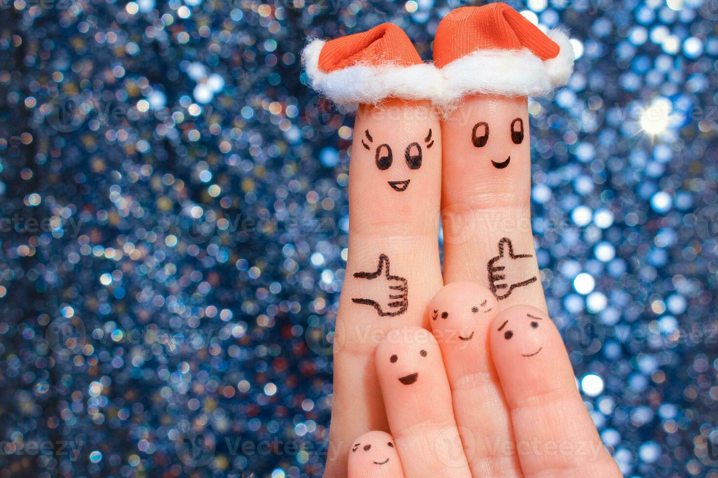 Finger art of large family celebrates Christmas. Concept of group of people laughing in new year hats. Happy couple showing thumbs up. Toned image. photo